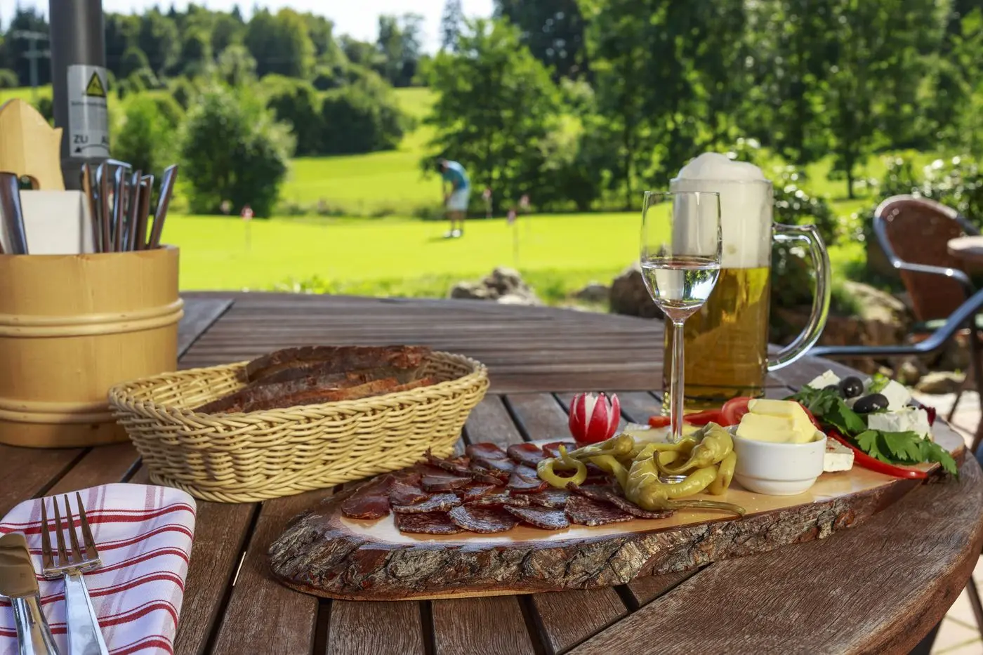 A laid table on the clubhouse restaurant terrace, with the course behind