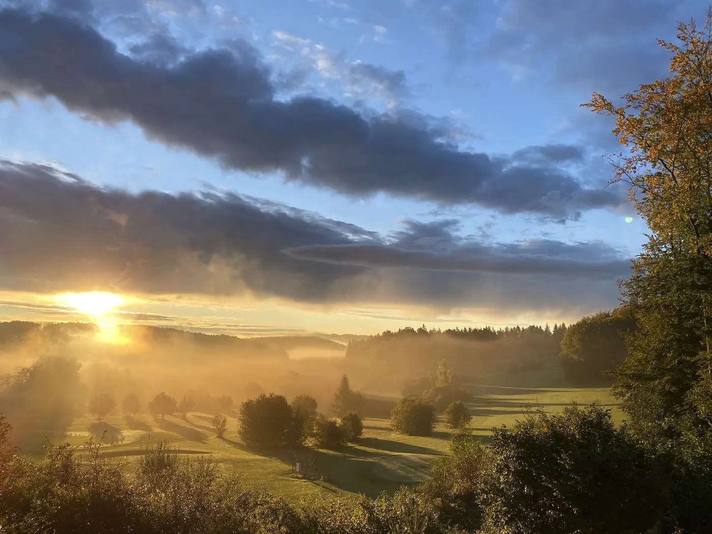 Sunrise over the course, mist in the valley