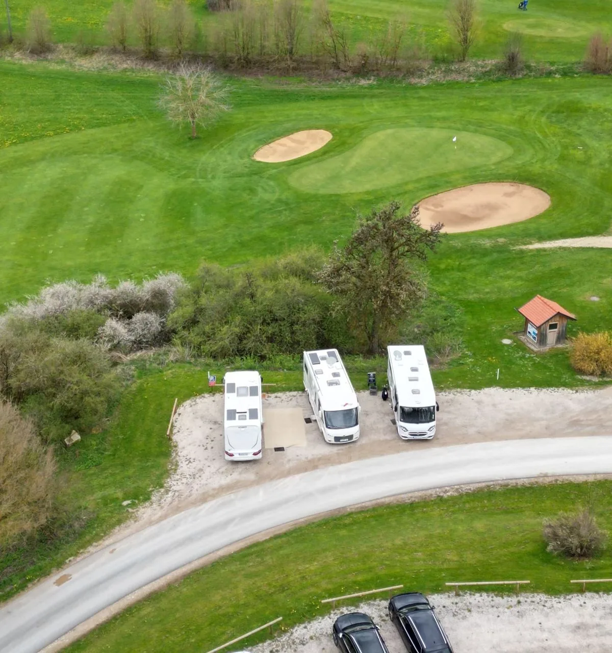 Aerial view of the pitches at the edge of the golf course, with the 18th green behind